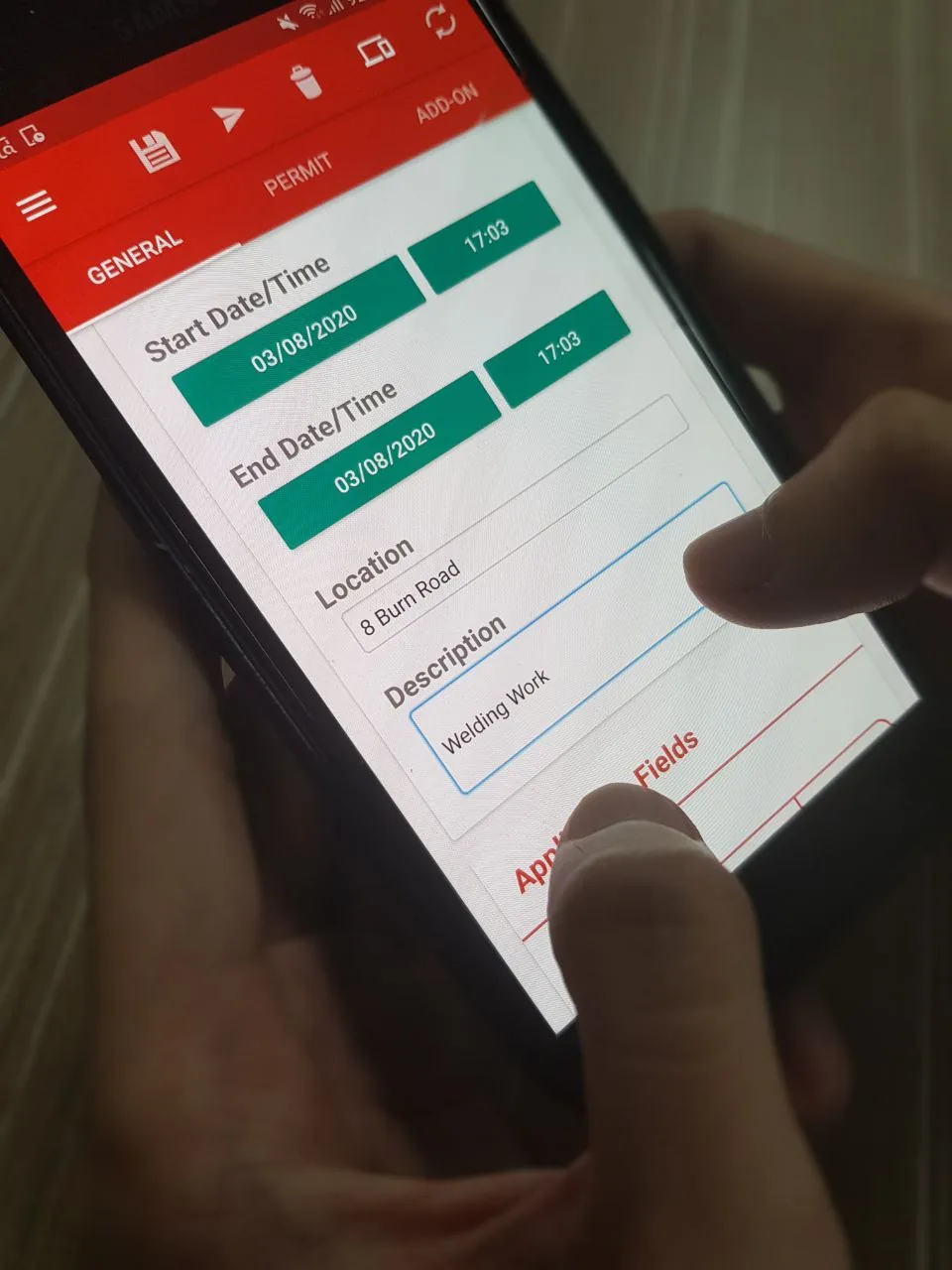 Site supervisor reviewing a permit to work on a tablet